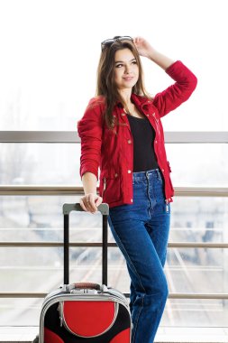 Kırmızı ayakta Terminal bavulla gözlüklü genç çekici kadın. Seyahate tanıştığım kız