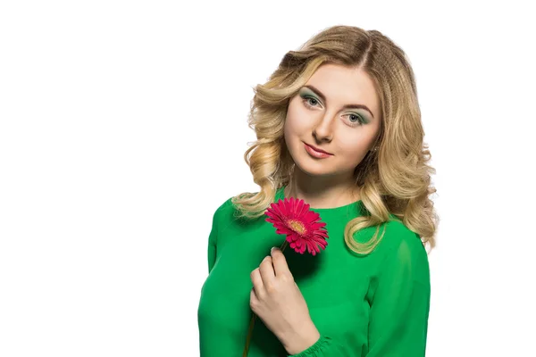 Retrato de uma bela mulher loira que está olhando para a câmera segurando uma flor de gerbera no fundo branco isolado — Fotografia de Stock