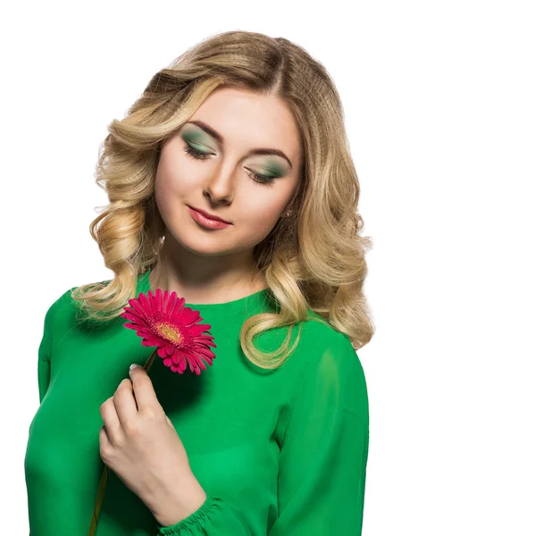 Retrato de uma bela mulher loira que está olhando para uma gerbera isolada em um fundo branco. menina segurando uma flor — Fotografia de Stock