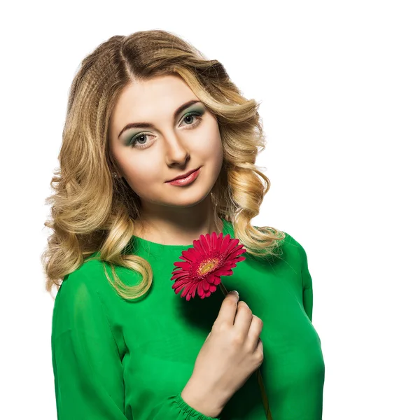 Bela mulher loira em um vestido verde que olha para a câmera enquanto segurando flor no fundo branco isolado . — Fotografia de Stock