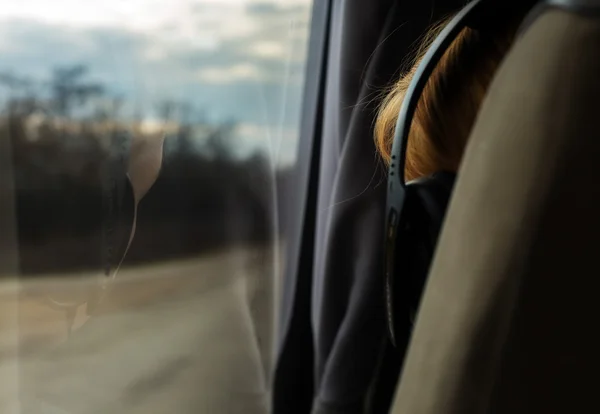 A reflection of a girl with headphones in the bus window. back view. close-up. On the Sunset — Stock Photo, Image