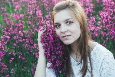 Güzel Gelin çiçek alanı. Beyaz elbiseli kız gün batımında yaz alanında bir buket ile