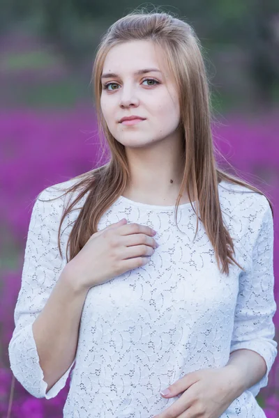 Krásná mladá nevěsta v poli, šťastné ženy těší květiny. — Stock fotografie