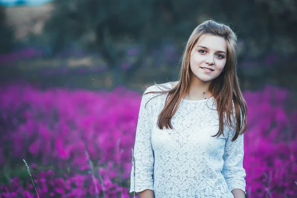 Bela noiva jovem no campo, mulher feliz apreciando flores . — Fotografia de Stock