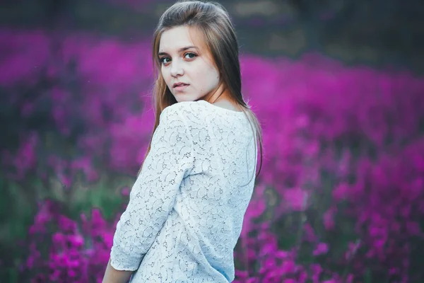 Mooie jonge bruid in veld, gelukkige vrouw genieten van bloemen. — Stockfoto