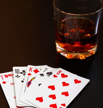 Bardak viski ve iskambil ahşap masa üzerinde siyah bir masa üzerine. Görüş açısı, kimlik kartları