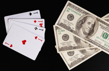 iskambil ve yüz dolarlık banknot siyah bir zemin üzerine.