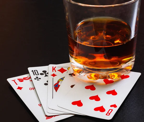 Glas Whiskey und Spielkarten auf einem schwarzen Tisch auf dem Holztisch. Blickwinkel, Ausweise — Stockfoto