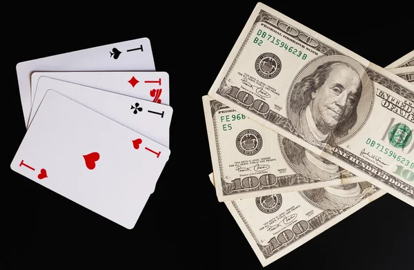 Spielkarten und Hundert-Dollar-Scheine auf schwarzem Hintergrund. — Stockfoto