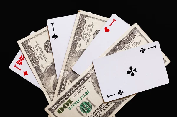 Carte da gioco e banconote da cento dollari su sfondo nero . — Foto Stock
