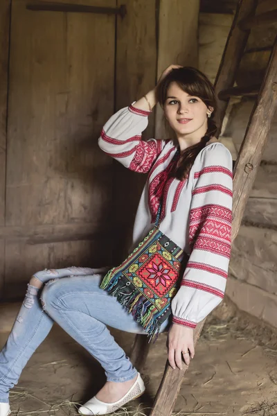 Junge Frau in traditioneller ukrainischer Tracht steht in der Nähe von Treppen in einem alten Haus — Stockfoto