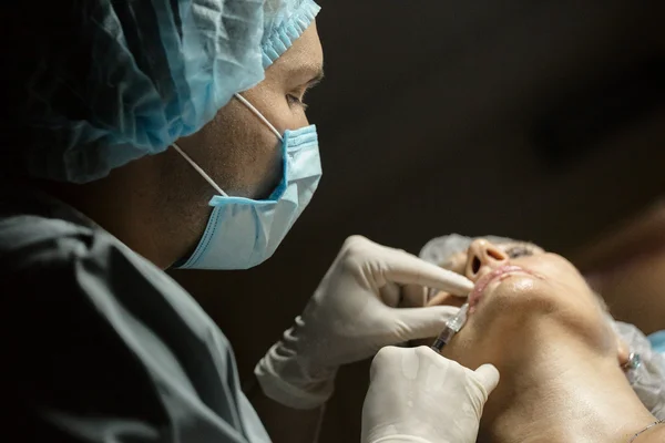 Medico cosmetologo che fa siringa per iniezione botox. Il medico fa un'iniezione in faccia alla cannula . — Foto Stock