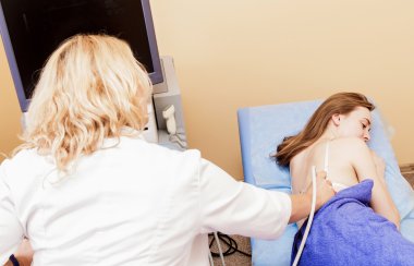 Ultrason ile genç bir kadın tarafından hospital.doctor ultrason aygıtı böbrekler üzerinde kontrol adam inceliyor