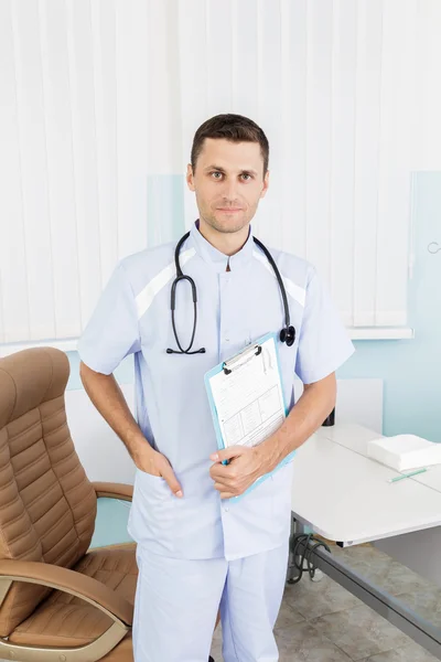Portrait of a young male doctor in his medical office. The workplace of the doctor at the clinic — Stock Photo, Image