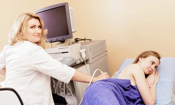 Ultrason ile genç bir kadın tarafından hospital.doctor ultrason aygıtı böbrekler üzerinde kontrol adam inceliyor