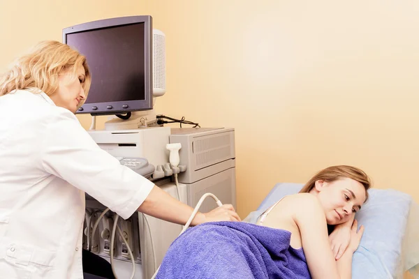 Ultrason ile genç bir kadın tarafından hospital.doctor ultrason aygıtı böbrekler üzerinde kontrol adam inceliyor