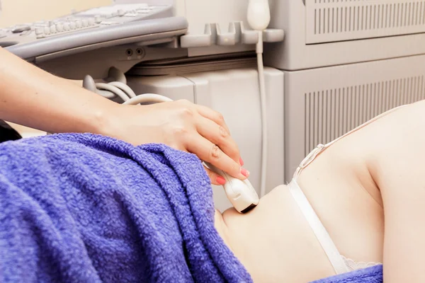 Ultrason ile genç bir kadın tarafından hospital.doctor ultrason aygıtı böbrekler üzerinde kontrol adam inceliyor