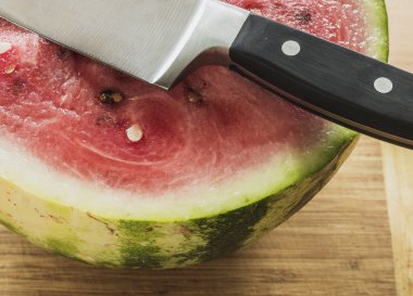 Bir ahşap masa, rustik, bıçak üzerinde bir dilim karpuz kesmek