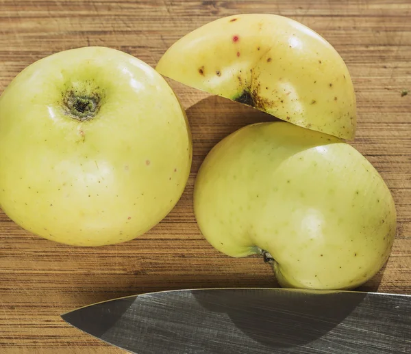 Yellow apples on wooden table,knife — Stock Photo, Image