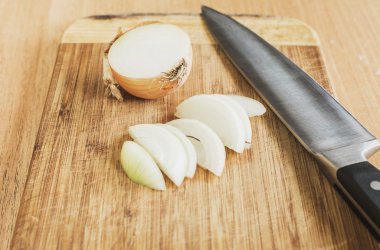 Ahşap arka plan üzerinde organik soğan gemide. Seçici odak, yatay. Bıçak