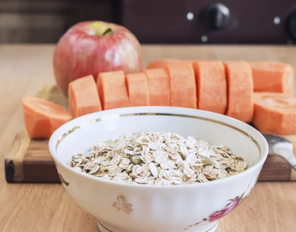 Los copos de avena y cuchara, zanahorias en rodajas, manzana — Foto de Stock