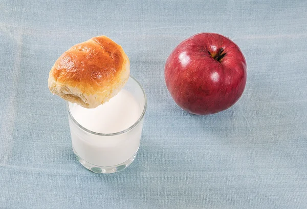 Pães frescos com maçã, pastéis assados um copo de leite — Fotografia de Stock