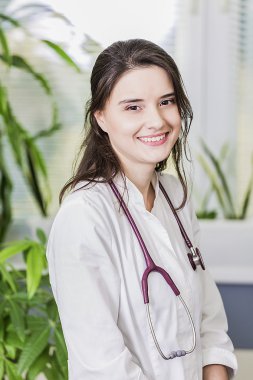 güzel kız doktor gülümseyen hastane içinde Beyaz önlük ayakta