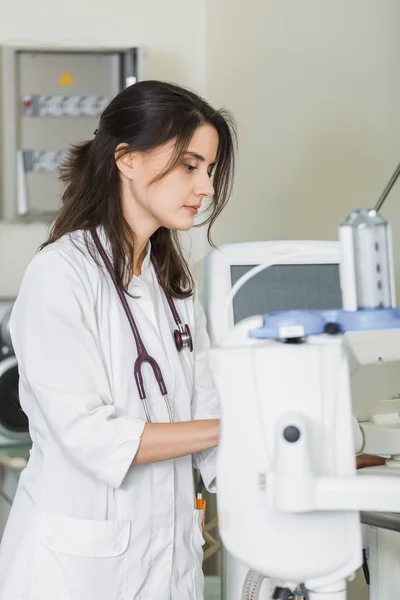 Beautiful girl doctor in a white coat working with medical equipment — Stockfoto