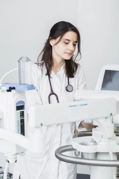 Beautiful girl doctor in a white coat working with medical equipment — Stockfoto