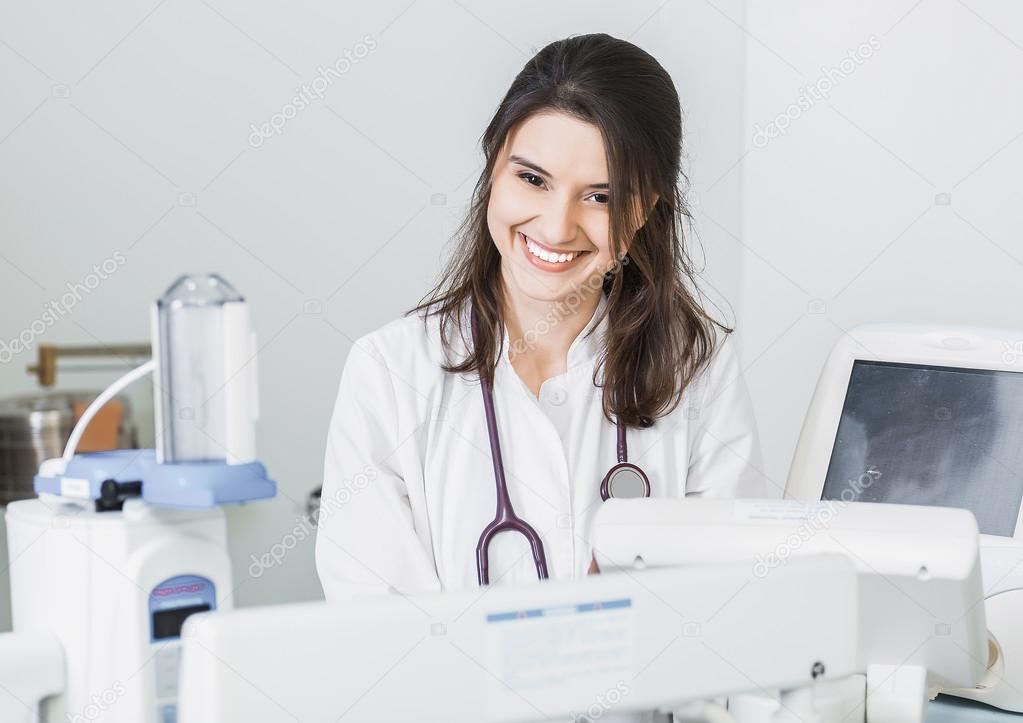 beautiful girl doctor in a white coat working with medical equipment