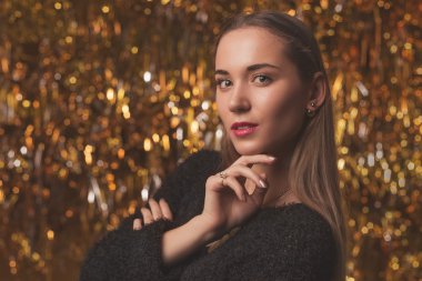 altın arka plan üzerinde siyah elbiseli genç güzel kız