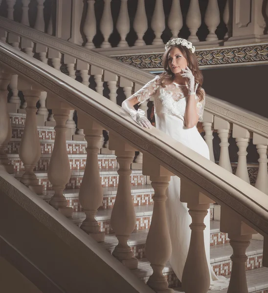 Cantik elegan gadis dalam gaun putih berdiri di tangga vintage di kastil — Stok Foto
