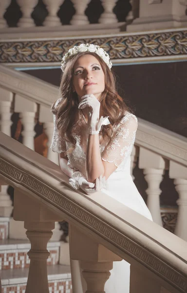 Bela menina elegante em um vestido branco em pé sobre escadas vintage no castelo — Fotografia de Stock
