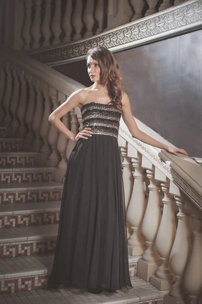 Krásná elegantní žena v černých šatech stojí na schodech vinobraní na zámku — Stock fotografie