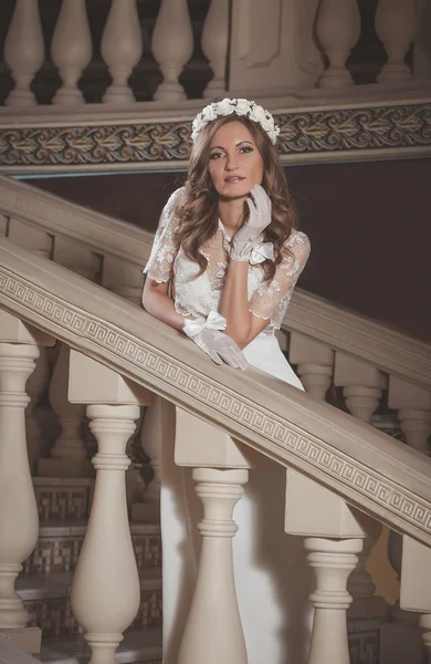 Hermosa chica elegante en un vestido blanco de pie en escaleras vintage en el castillo —  Fotos de Stock