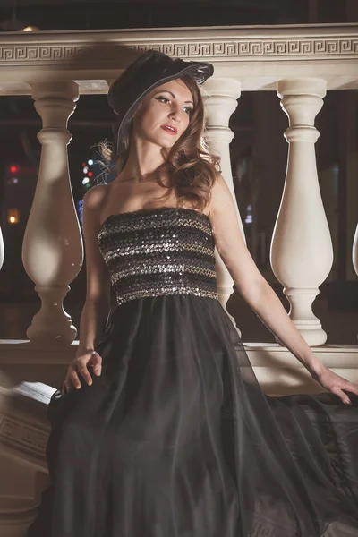 Krásná elegantní žena v černých šatech sedět na zábradlí vinobraní na zámku — Stock fotografie
