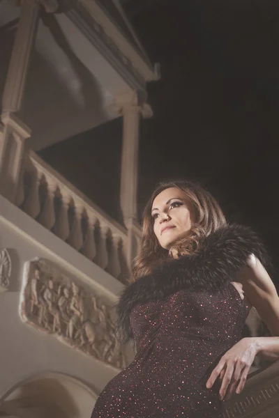 Bela mulher elegante em um vestido marrom em pé na escadaria vintage no castelo — Fotografia de Stock