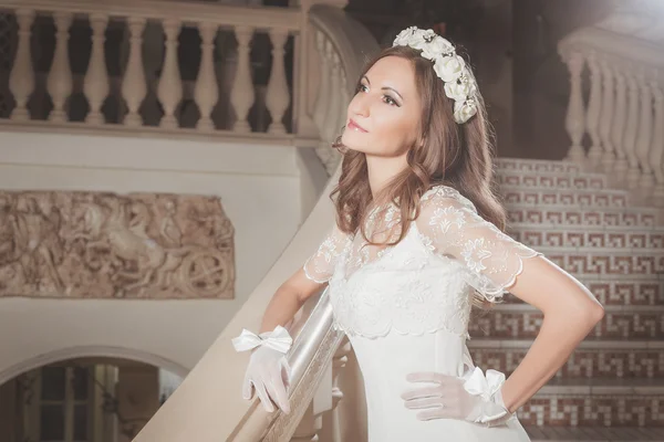 Bella ragazza elegante in un abito bianco in piedi su scale d'epoca nel castello — Foto Stock