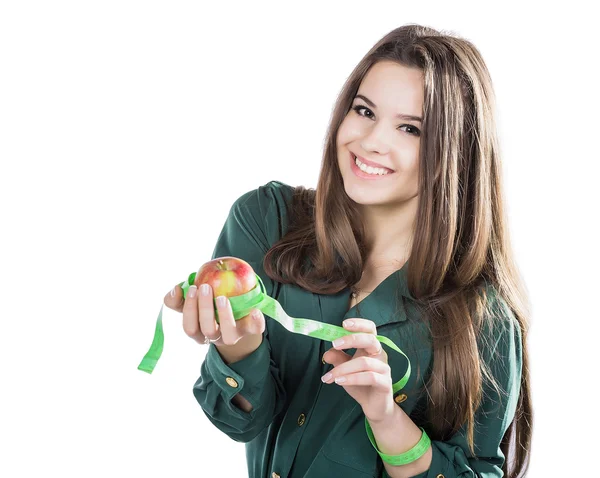 Giovane bella ragazza con i capelli scuri isolati su uno sfondo bianco che tiene una mela con un metro a nastro. — Foto Stock