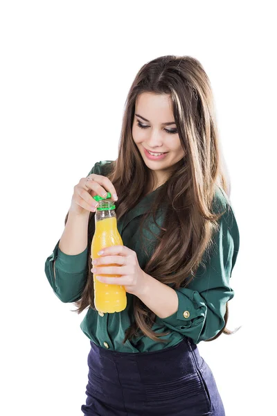 Adolescente feliz mientras sostiene una botella de jugo de naranja.en una blusa verde. aislado sobre un fondo blanco.Abre una botella — Foto de Stock