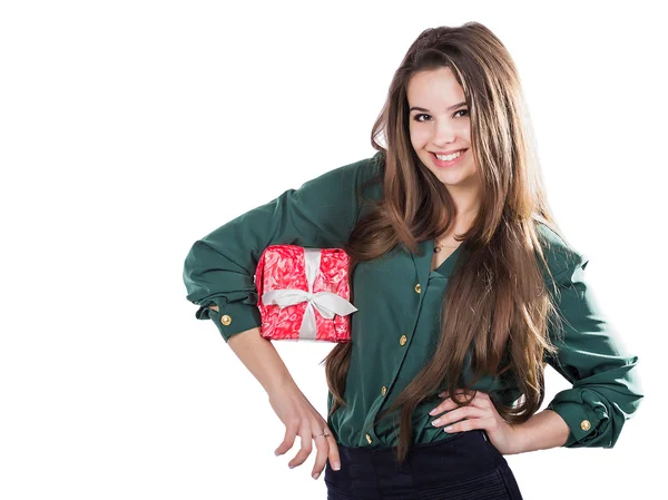 Beautiful young girl on a white background holding a box with a gift. Smiles. — стокове фото