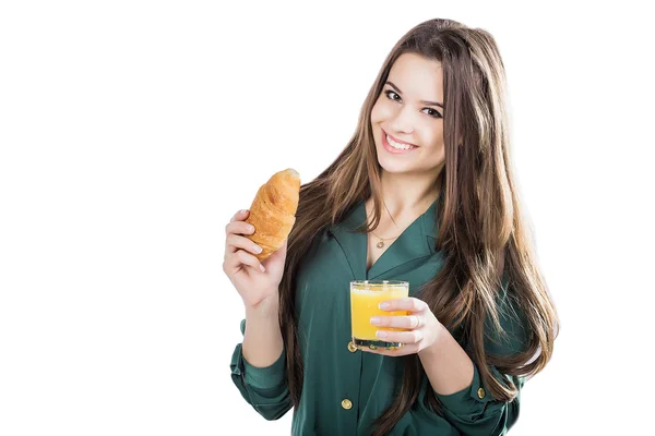 Young woman with glass of juice and croissant — 스톡 사진