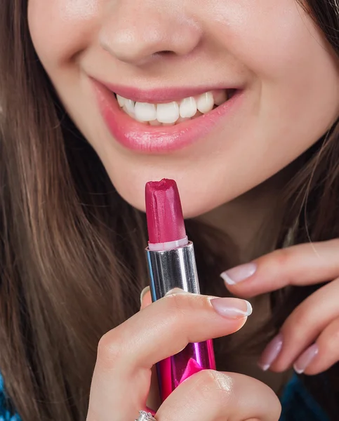 Gros plan d'une jolie fille elle ouvrit la bouche et leur mit du rouge à lèvres rouge. Sourires. Yeux bruns . — Photo