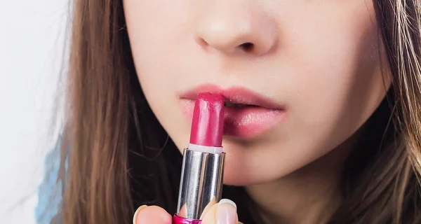 Close up de uma menina atraente ela abriu a boca e colocá-los batom vermelho. Sorrisos. Olhos castanhos . — Fotografia de Stock