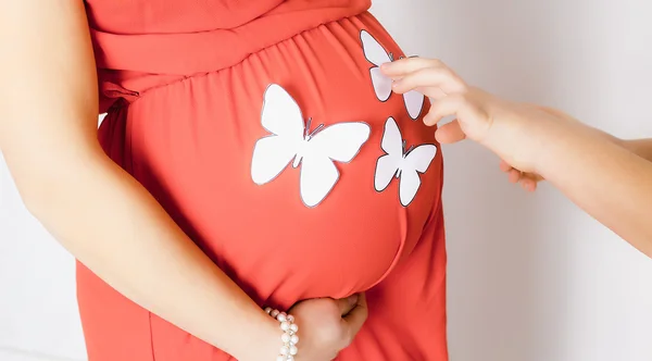 In the red dress pregnant woman white paper butterfly — 스톡 사진