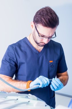 healthcare, profession, stomatology and medicine concept - male  dentist over medical office background