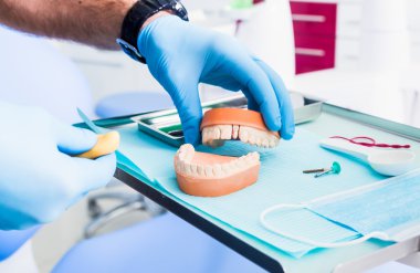 Closeup of male dental technician working in dental laboratory.dental acrylic prosthesis