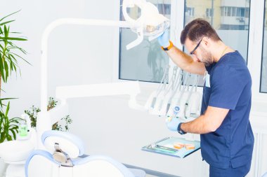 healthcare, profession, stomatology and medicine concept -  male dentist  over medical office background