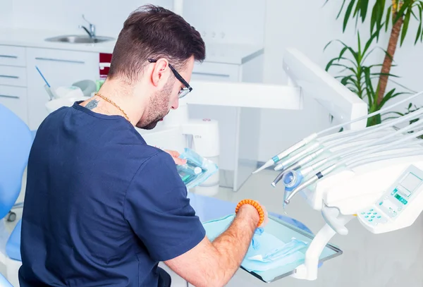 healthcare, profession, stomatology and medicine concept - male  dentist over medical office background