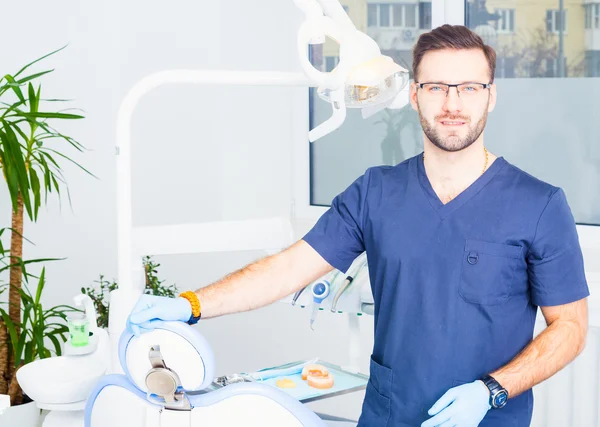 Healthcare, profession, stomatology and medicine concept - smiling male dentist  over medical office background — 스톡 사진
